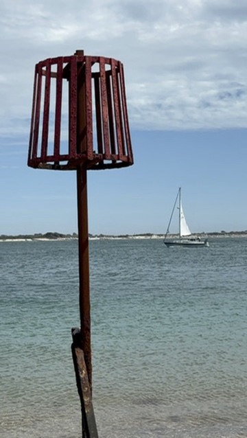 Beacon and sailboat in Chichester Harbour
